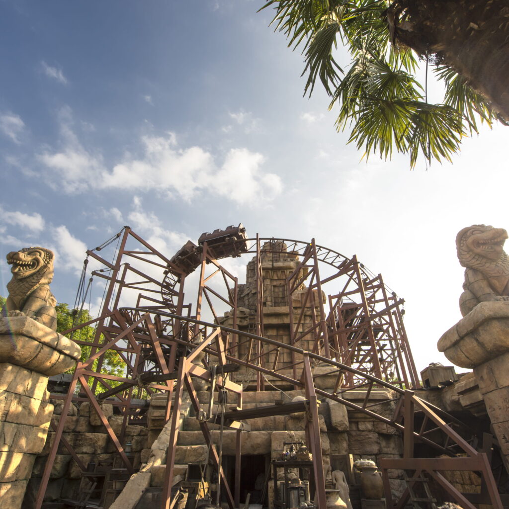 Attraction Indiana Jones et le Temple du Péril à Disneyland Paris, au cœur de ruines antiques en pierre ornées de statues de serpents.